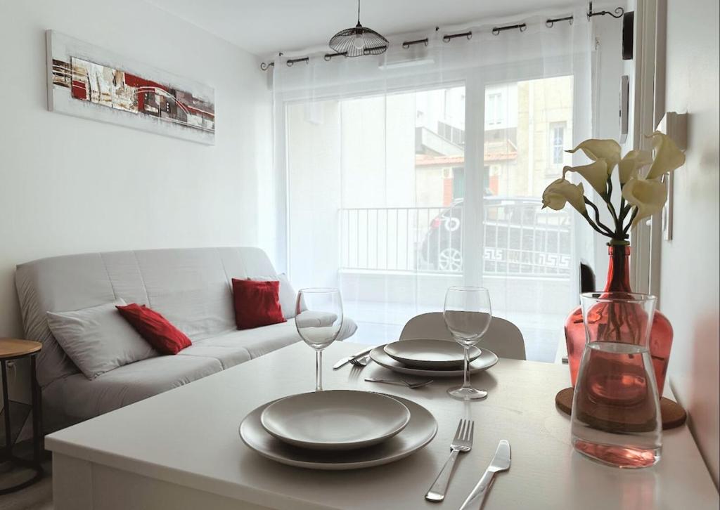 - un salon doté d'une table avec des assiettes et des verres à vin dans l'établissement Zen Milton calme neuf idéal couple, à Nancy