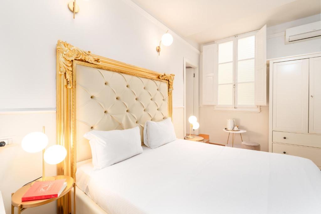a bedroom with a large white bed with a gold frame at Residenza Conte di Cavour & Rooftop in Florence