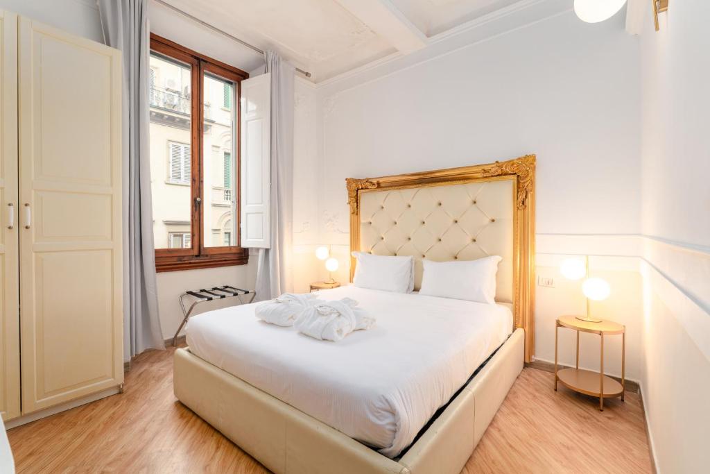 a bedroom with a white bed and a window at Residenza Conte di Cavour & Rooftop in Florence