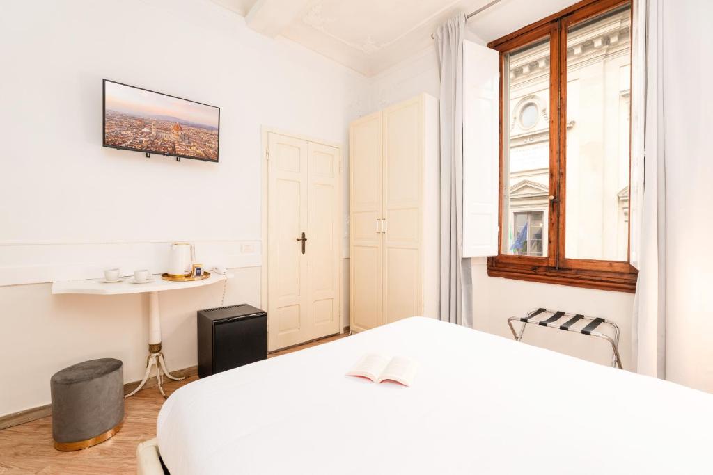 a white bedroom with a bed and a window at Residenza Conte di Cavour & Rooftop in Florence