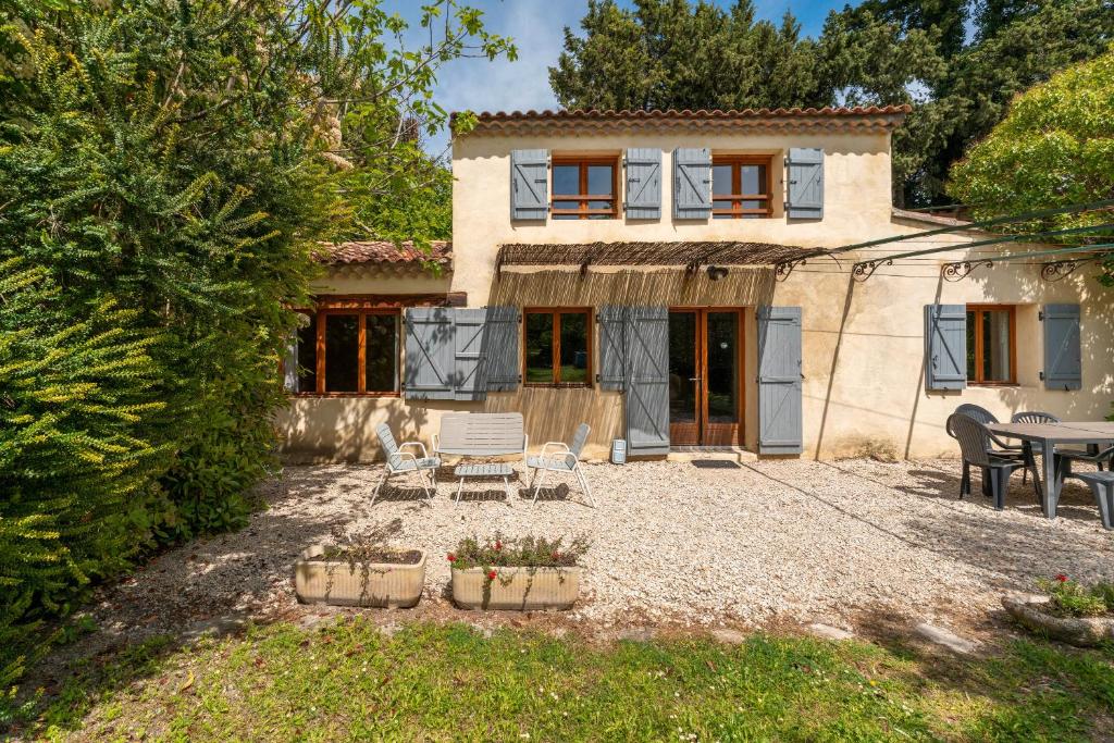 une maison avec une table et des chaises dans une cour dans l'établissement La petite Palasse, au Thor