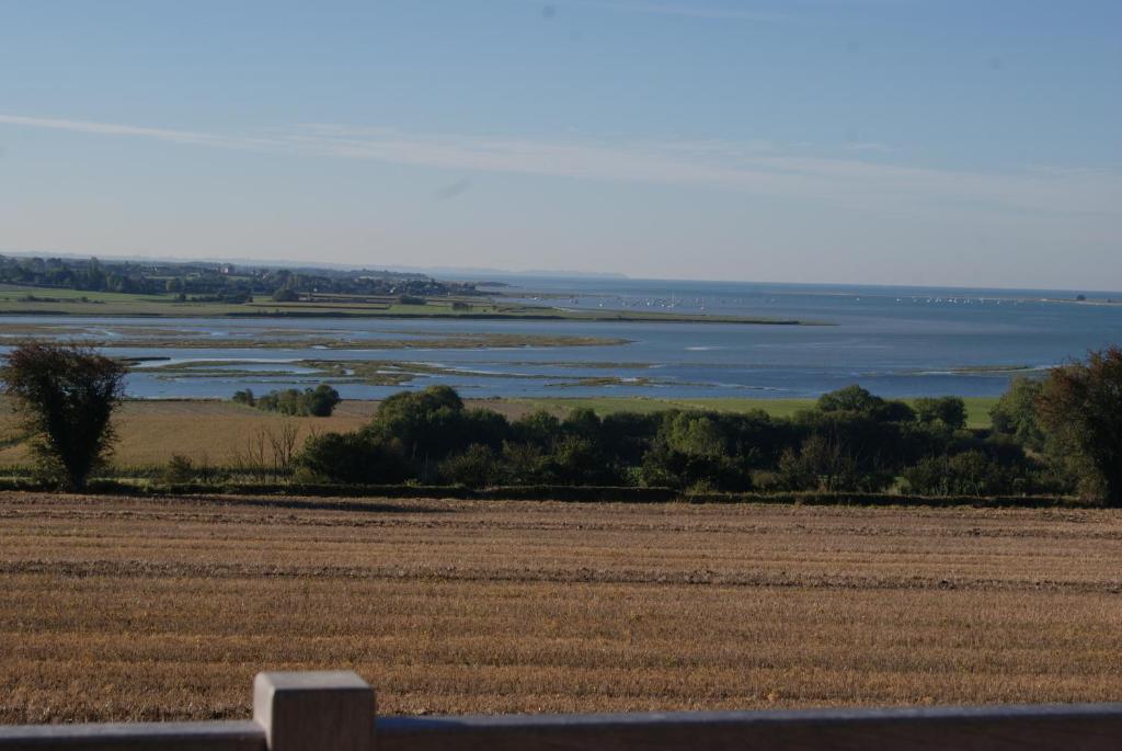 un champ avec vue sur l'eau dans l'établissement La Chambre de l'Amiral, à Tourville-sur-Sienne