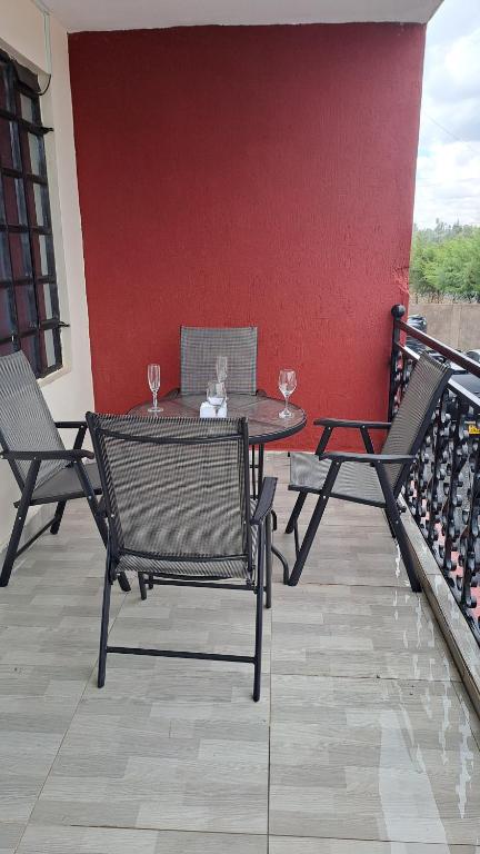 een terras met twee stoelen en een tafel met wijnglazen bij The Blissful Pitstop in Gatunga