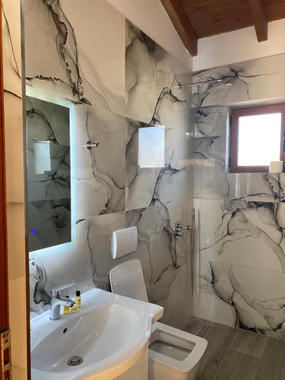 a bathroom with a white sink and a shower at Hotel Marku in Ksamil