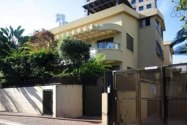 a building with a fence in front of it at Shelly's Home Boutique Apartments in Ramat Gan