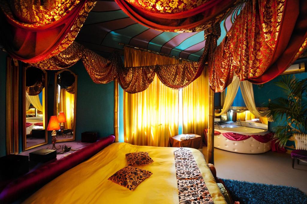 sypialnia z dużym łóżkiem i dużym lustrem w obiekcie Abali' Gran Sultanato w mieście Palermo
