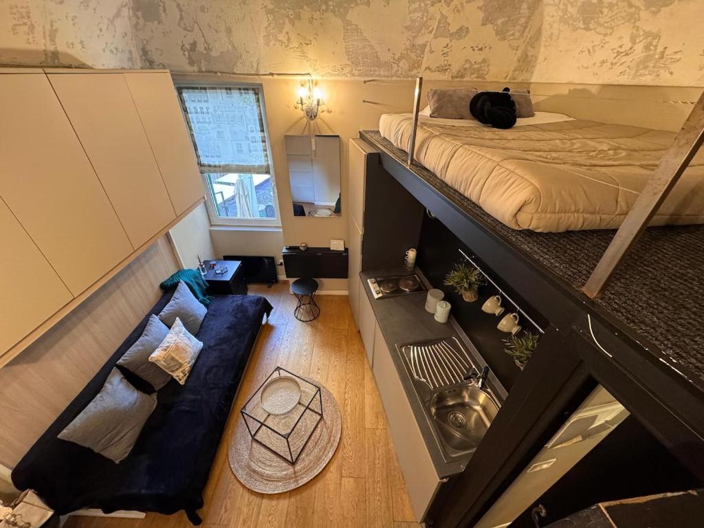 een kleine kamer met een bed en een bank bij Via Corradi in Sanremo