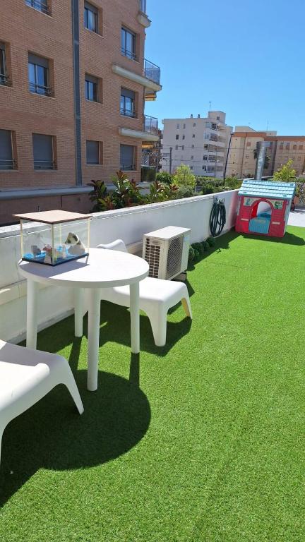 a balcony with a table and chairs on the grass at Apartamento con encanto in Torredembarra