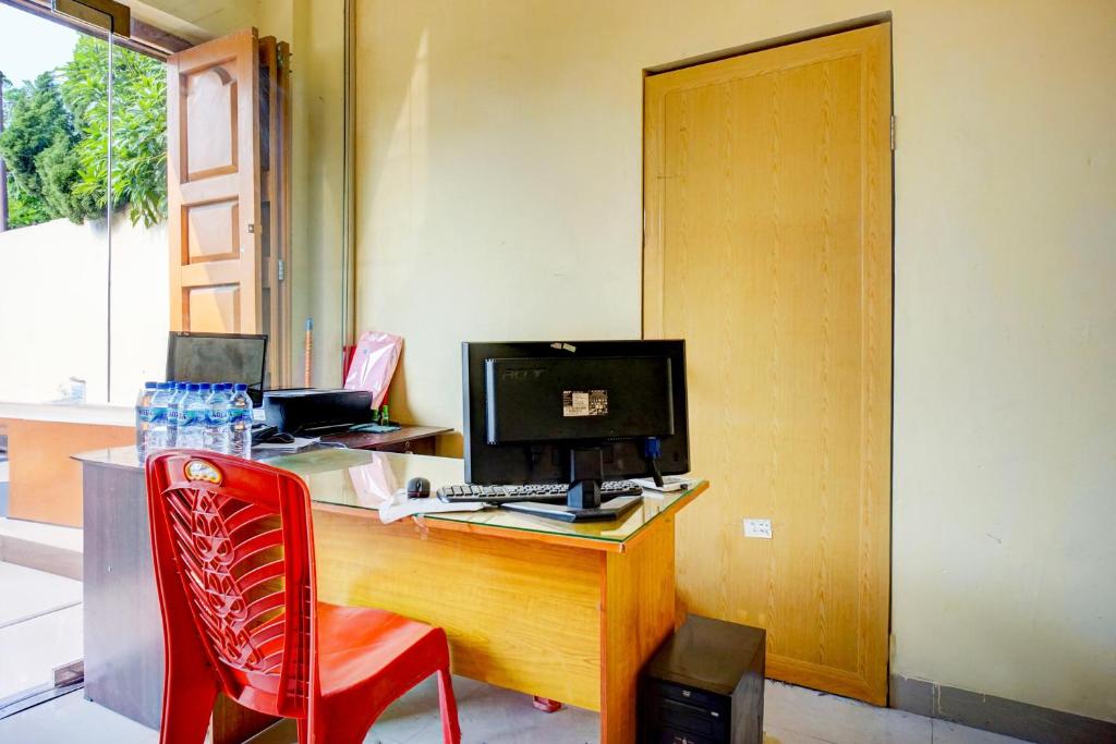 an office with a desk with a computer and a red chair at Dancenter Helvetia Near Plaza Millenium Formerly Sunny Inn in Medan