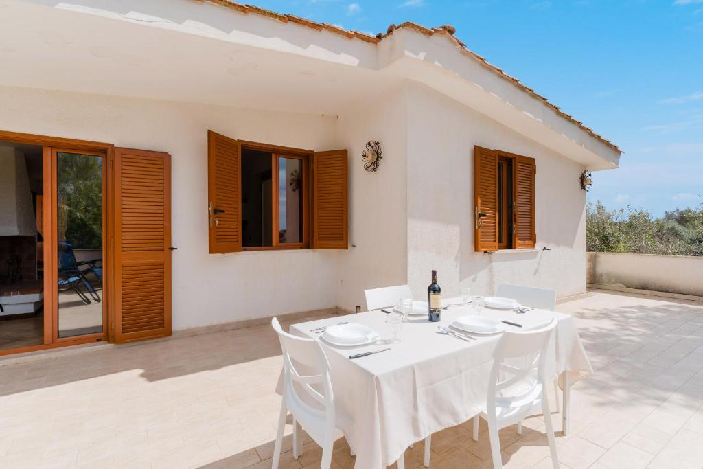 a white dining room with a white table and chairs at Casa Giogre' by BarbarHouse in Sant'Isidoro