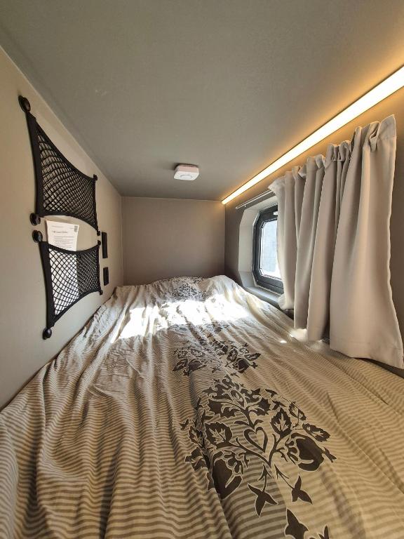 a large bed in a small room with a window at Eazy-Bed Norway's Smallest Hotel in Tromsø