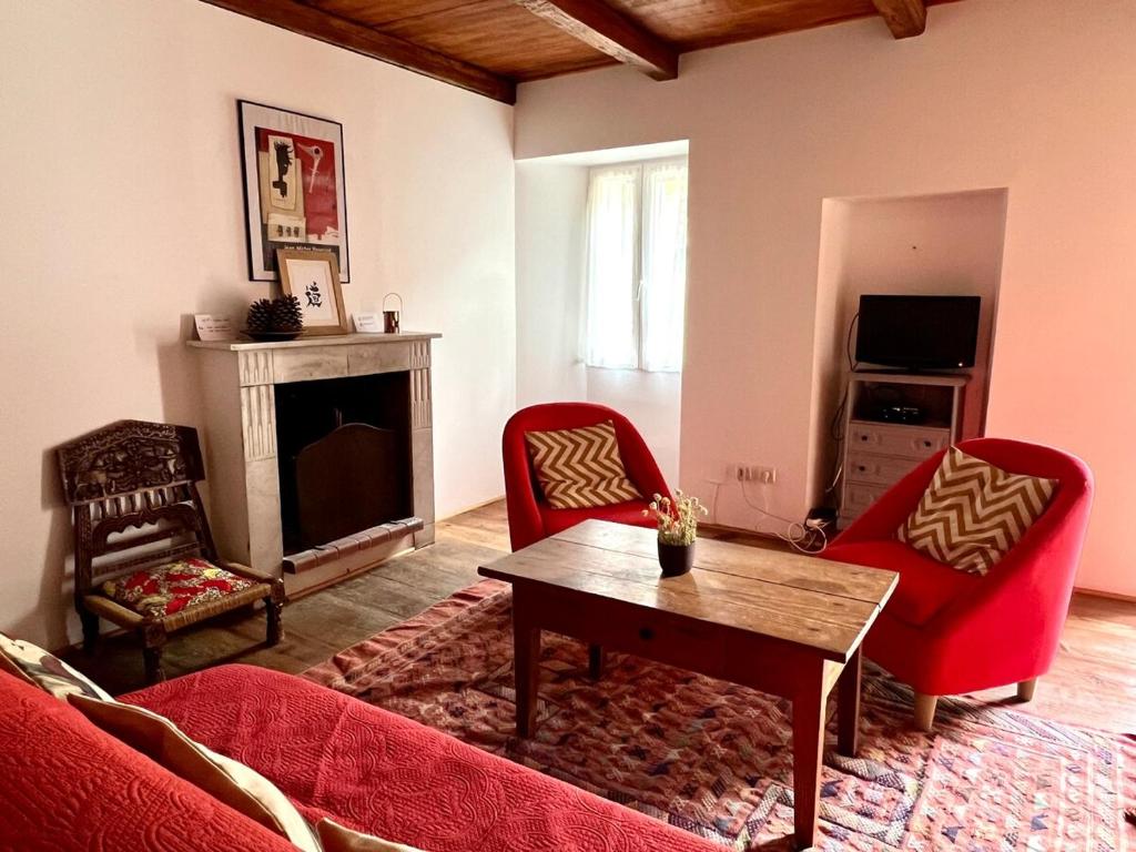 un salon avec un canapé rouge et une table dans l'établissement Maison de village Da Margot, à Lozzi