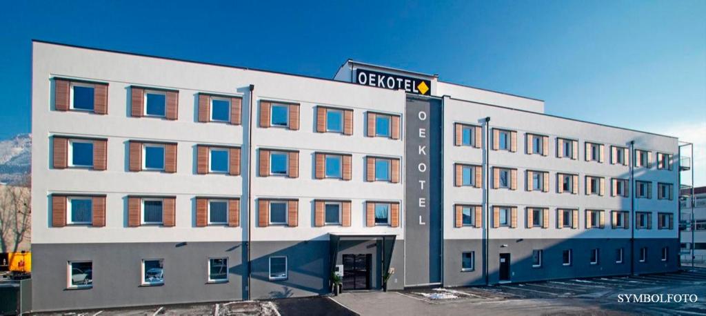 duży biały budynek z znakiem ulicznym w obiekcie OEKOTEL Graz Airport w mieście Kalsdorf bei Graz