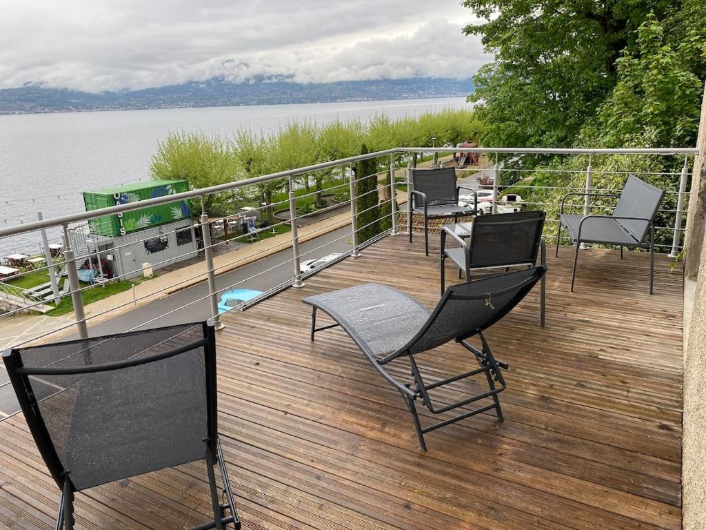 une terrasse avec des chaises et une table sur l'eau dans l'établissement Les Brises, à Saint-Gingolph