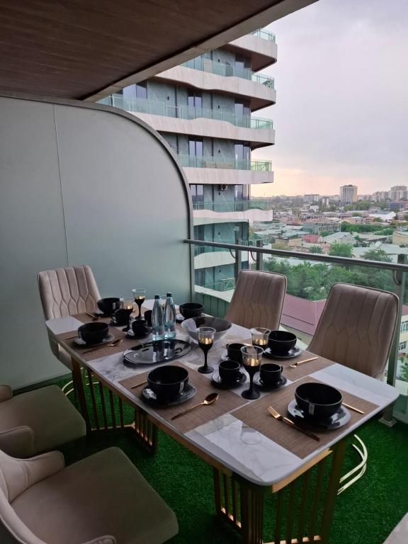 a table with bowls and plates on it on a balcony at Modern Stroy 55 by Royal Rentals in Yunusobod