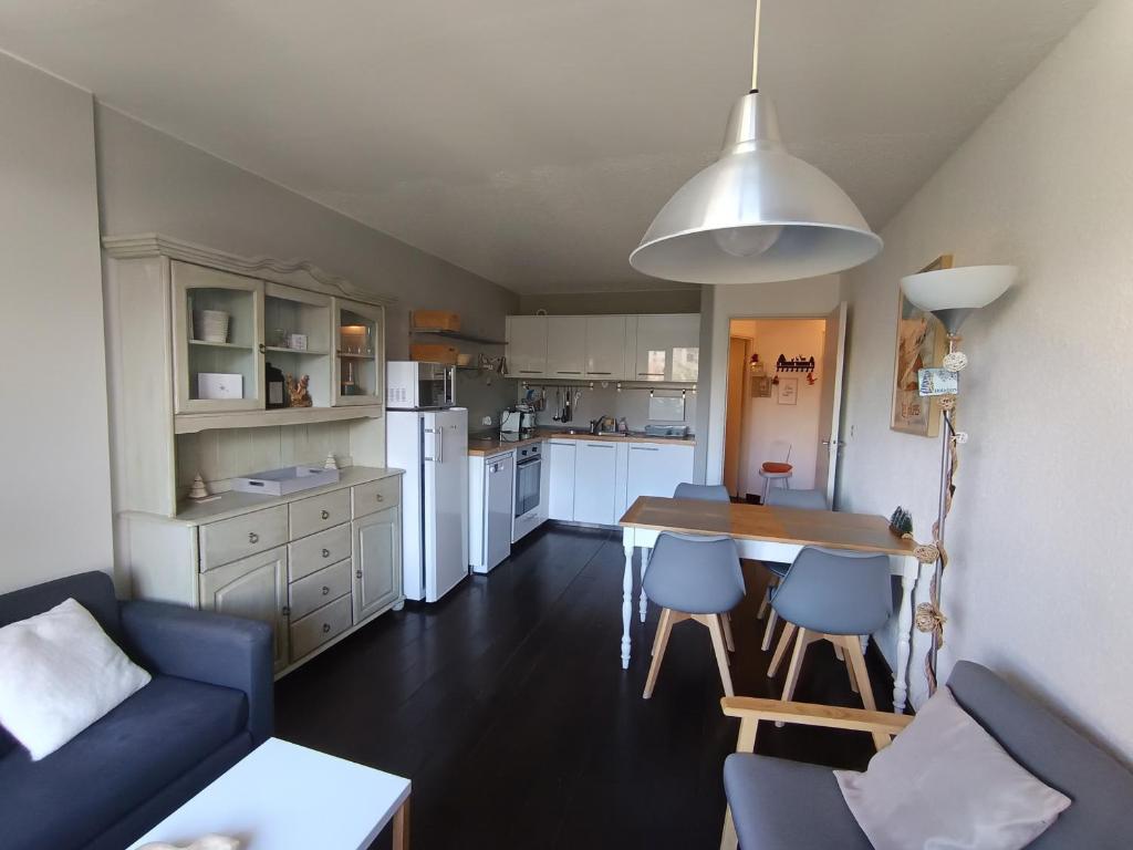 une cuisine avec une table et des chaises dans une pièce dans l'établissement Appartement confortable 4 pers, balcon soleil, parking, près des pistes - FR-1-445-172, à Montgenèvre