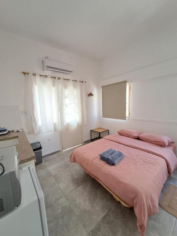 una camera da letto con un letto grande con lenzuola rosa di Terminal-Haifa port a Haifa