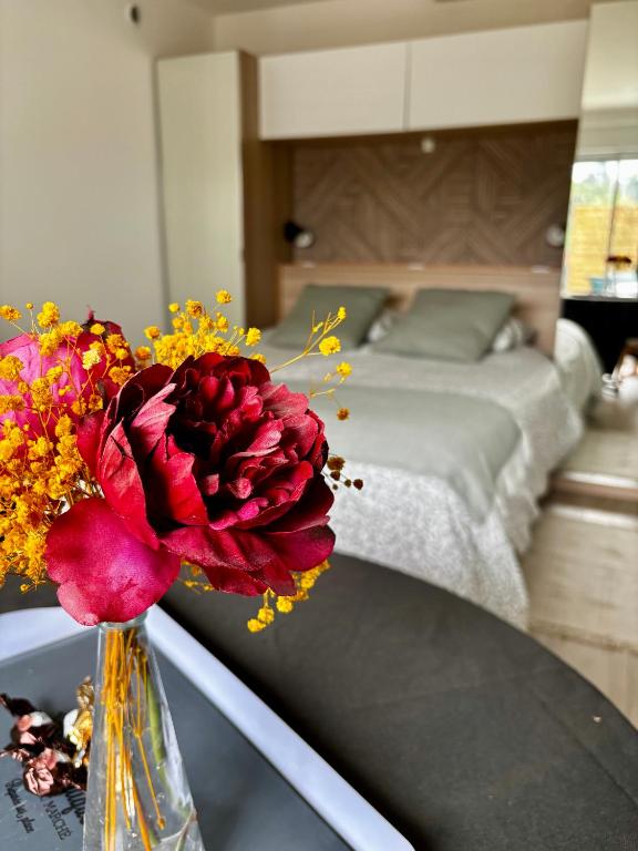 un vase avec une fleur rouge sur une table dans une chambre dans l'établissement Escapade au soleil studio au calme avec parking, à Cagnes-sur-Mer