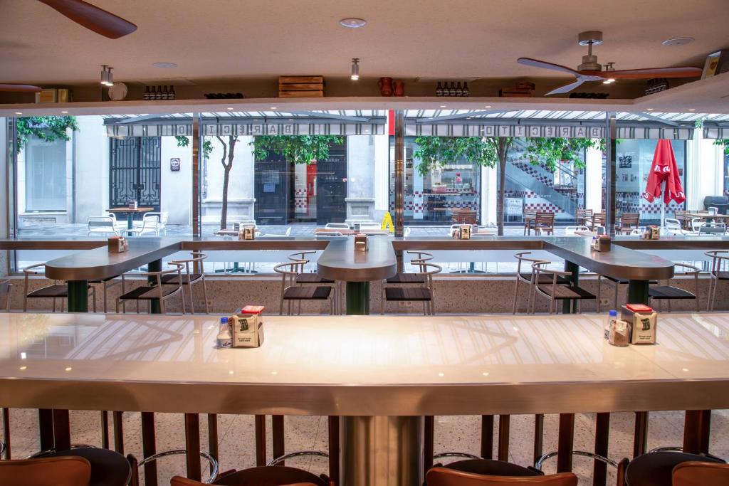 a row of tables and chairs in a restaurant at Melia Plaza Valencia in Valencia