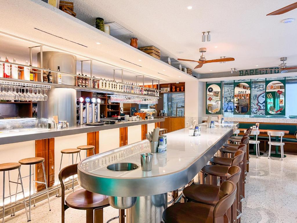 a restaurant with a long bar with stools at Melia Plaza Valencia in Valencia