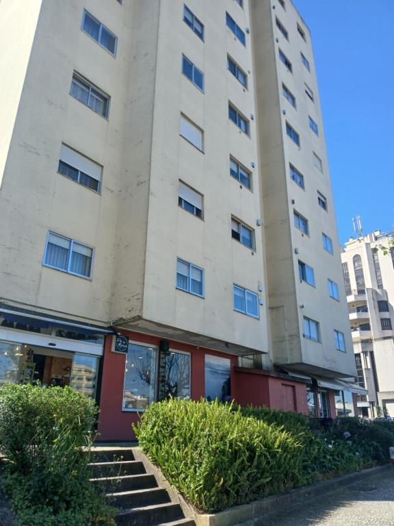 un alto edificio bianco con scale di fronte di Praça da Cidade a Oliveira de Azeméis