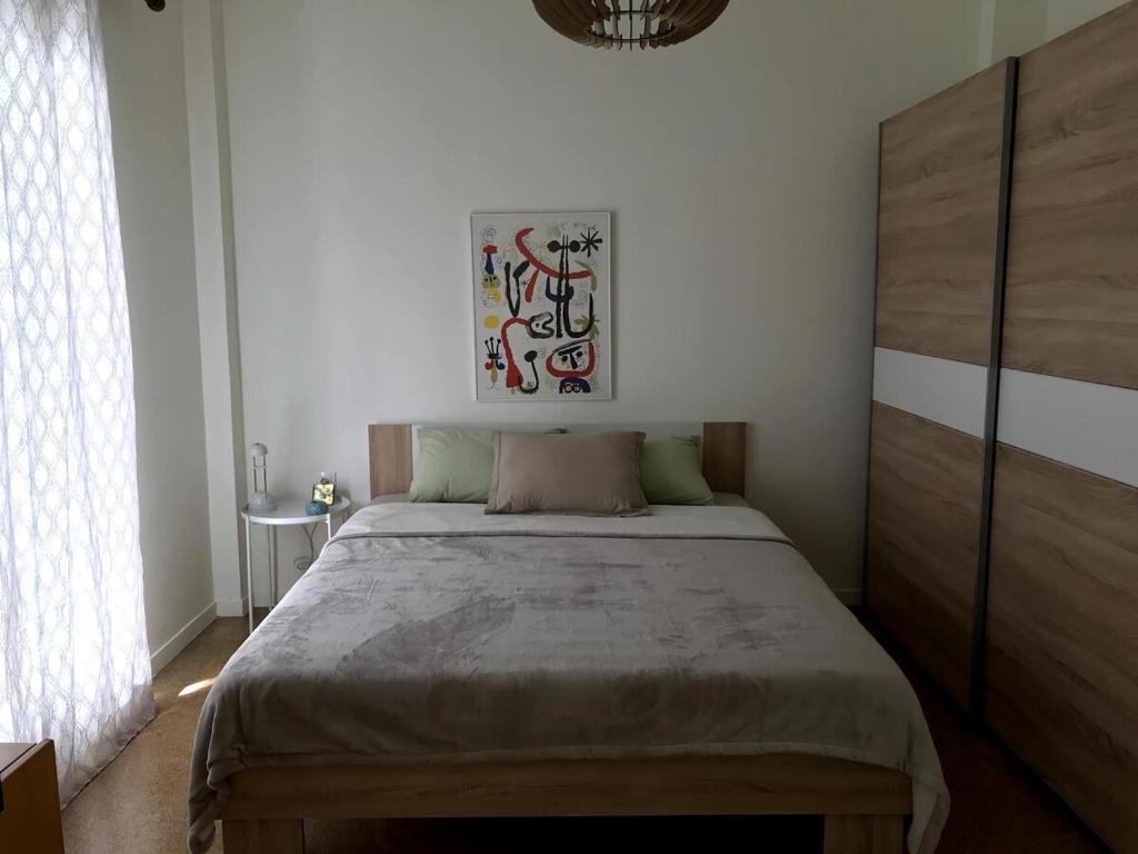 a bedroom with a bed with a wooden headboard at Central -I- Apartment in Athens