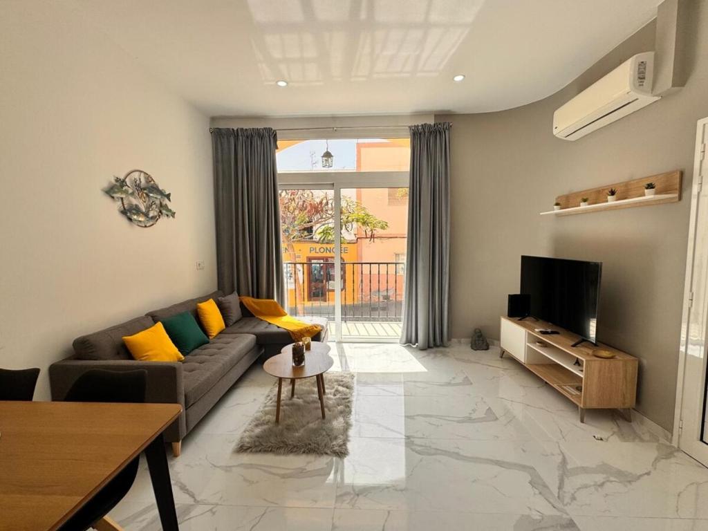 a living room with a couch and a television at Casa Fe in Morro del Jable