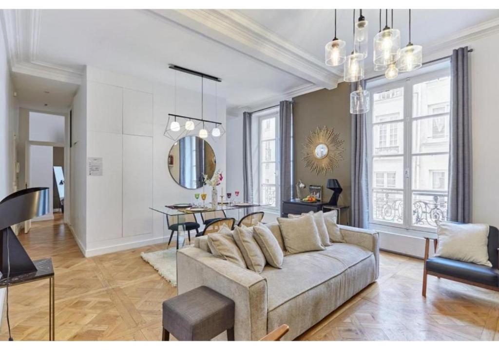 un salon avec un canapé et une salle à manger dans l'établissement Apartment Le Marais by Studio prestige, à Paris
