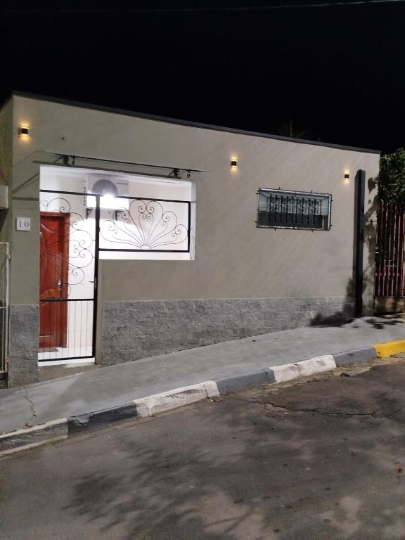 a white building with a gate and a window at AH Amabille House in Serra Negra