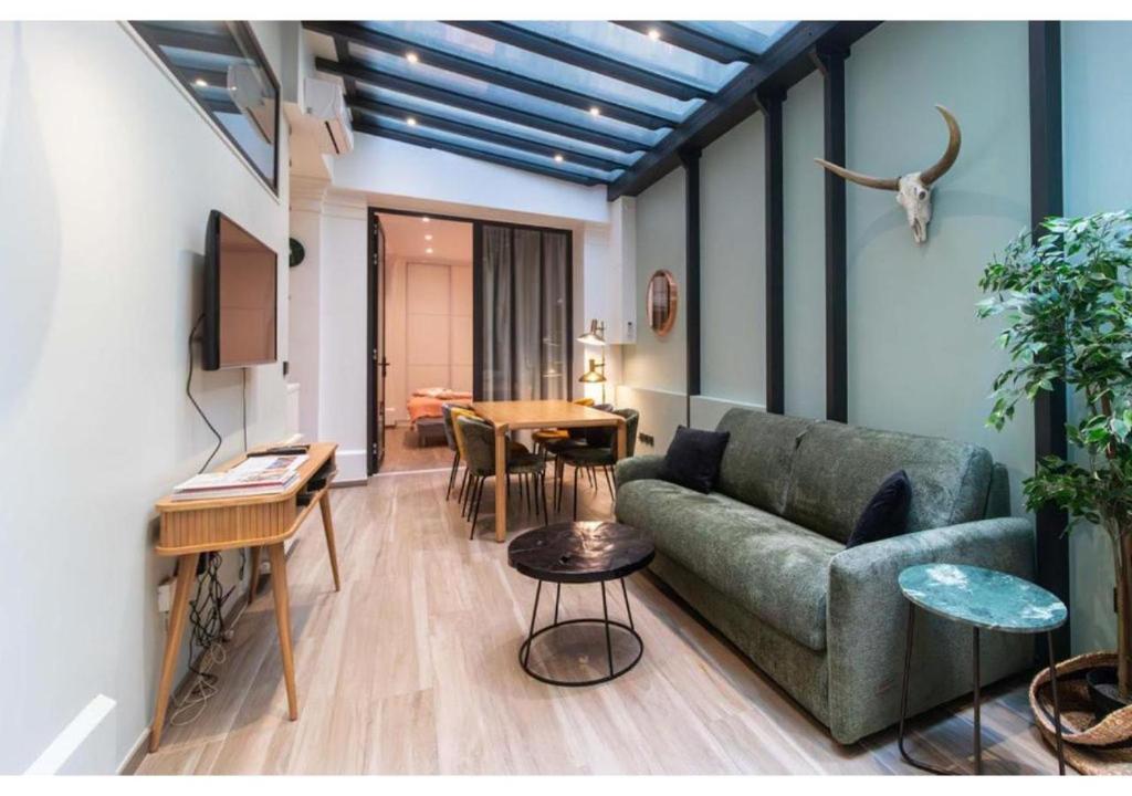 un salon avec un canapé et une table dans l'établissement Apartment Saint Germain des Près by Studio prestige, à Paris