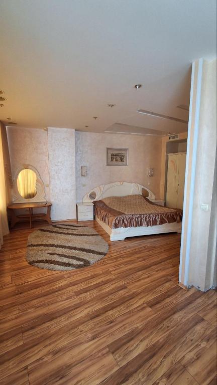 Un dormitorio con una cama y suelo de madera. en Проспект Дмитра Яворницького 4, en Dnipro