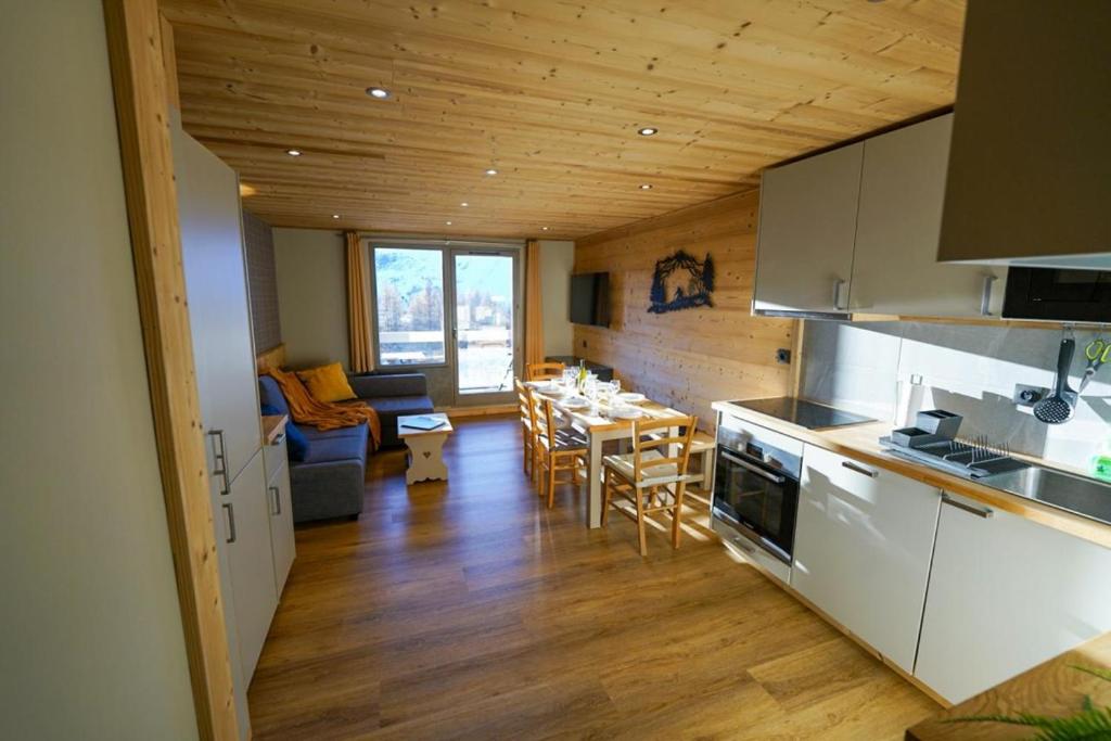 une cuisine et un salon avec une table et des chaises dans l'établissement HSH Huez Sweet Huez, à L'Alpe-d'Huez