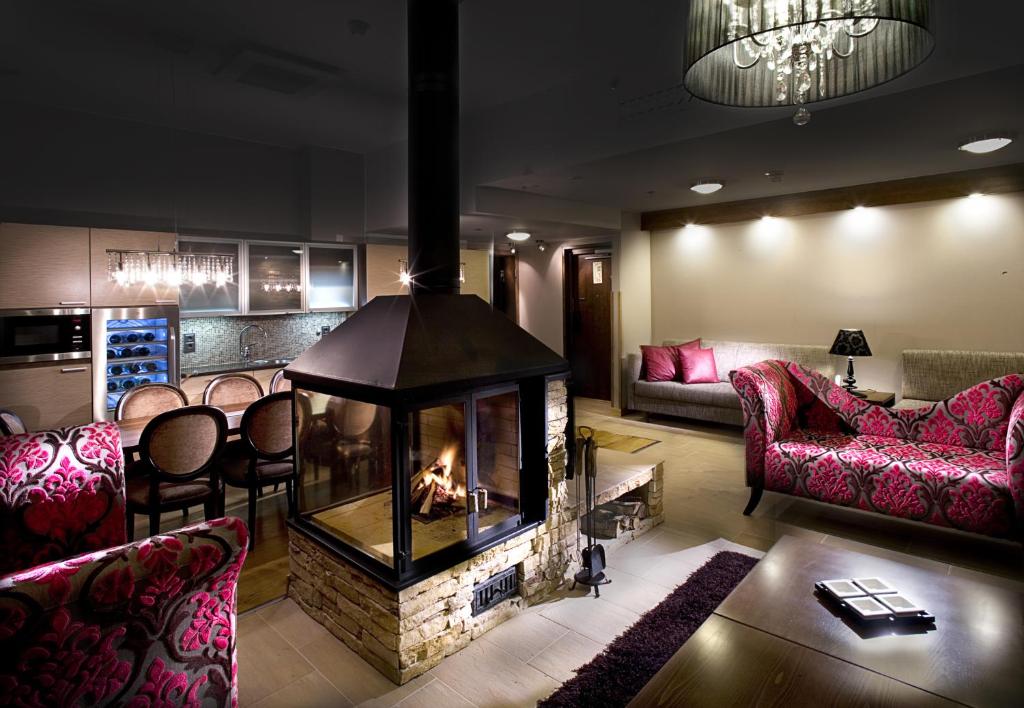 a living room with a fireplace in the middle at Santa's Hotel Santa Claus in Rovaniemi