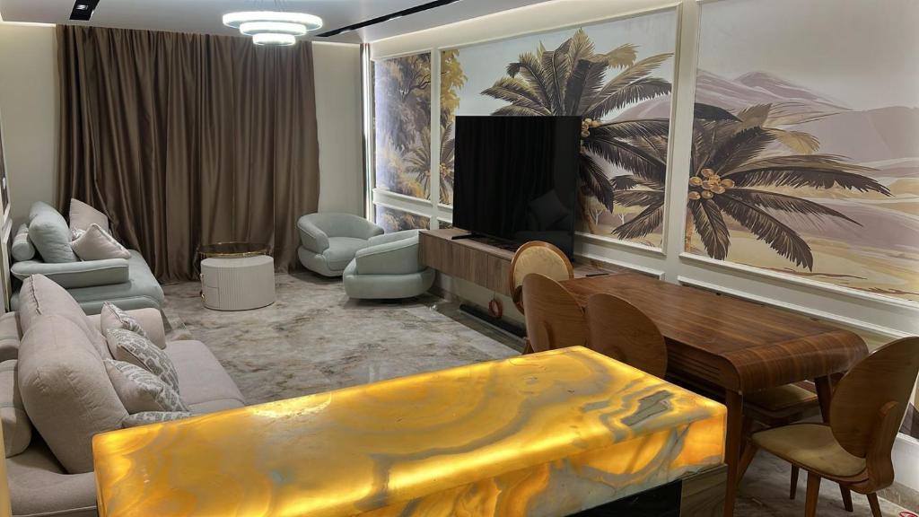 a living room with a couch and a tv in it at Compound Gardaina city in Cairo