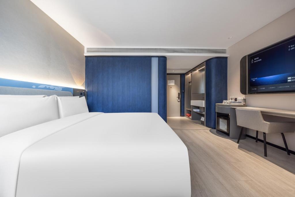 una camera d'albergo con un letto grande e una TV a schermo piatto di Atour Light Hotel Nanjing Xinjiekou Hanzhongmen Subway Station a Nanjing