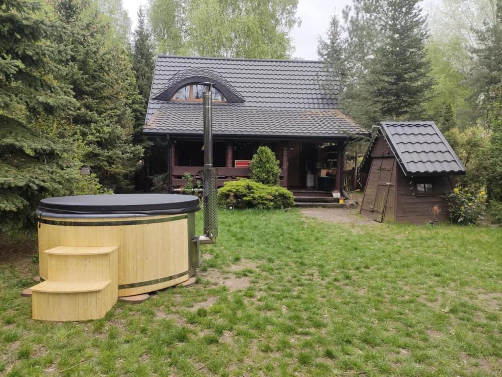 ein Haus mit einer großen Mülltonne im Hof in der Unterkunft Domek Nowy Lubiel in Lubiel Stary