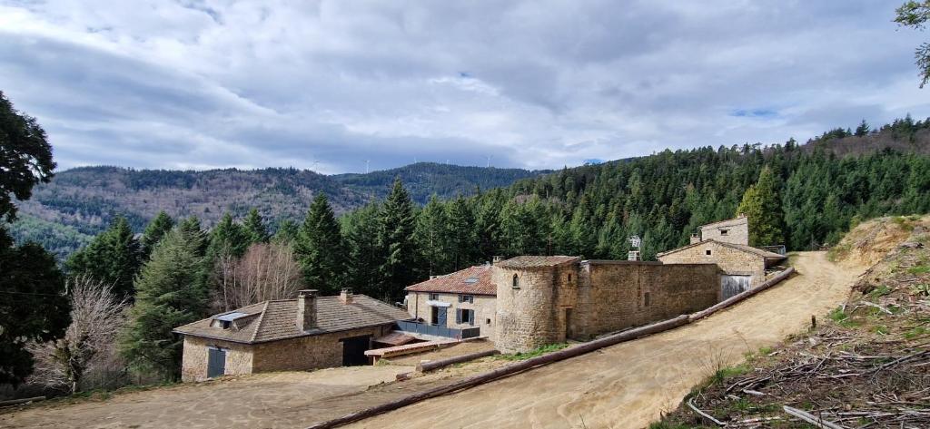 un vieux bâtiment sur le côté d'une colline dans l'établissement Domaine le Bouissou Du Mahun Gîtes de groupes en pleine forêt Ardéchoise, à Saint-Symphorien-de-Mahun