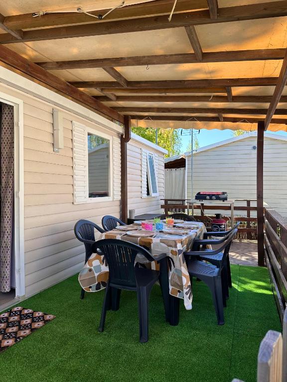 un patio avec une table et des chaises sur l'herbe dans l'établissement Mobil-home Elite 4-6 pers - Vias Camping La Carabasse, à Vias