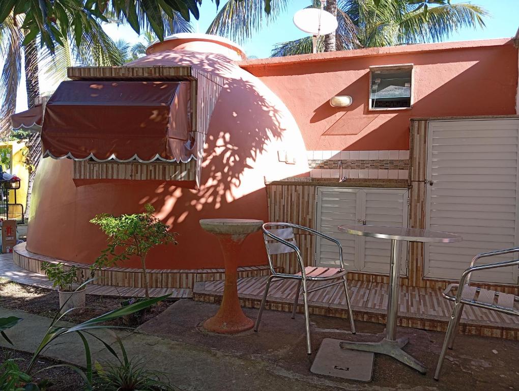 a house with a table and chairs in front of it at Chalé em Búzios 100m da Praia de Tucuns in Búzios