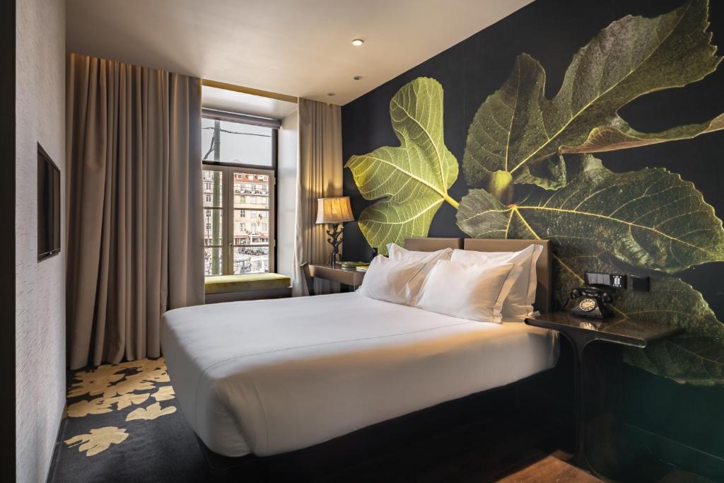 a hotel room with a bed with large leaves on the wall at Figueira by The Beautique Hotels & Spa in Lisbon