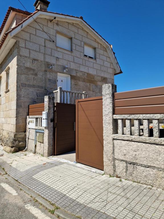 a brick house with a wooden garage door at House Capitán Nemo B in Redondela