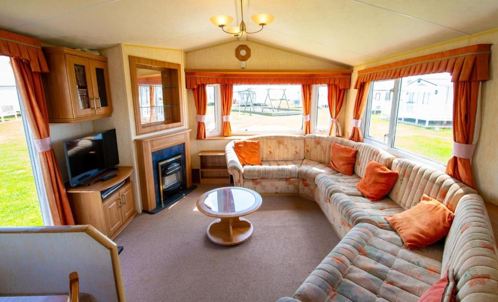 a living room with a couch and a tv at WW252 Parkdean Camber Sands in Camber