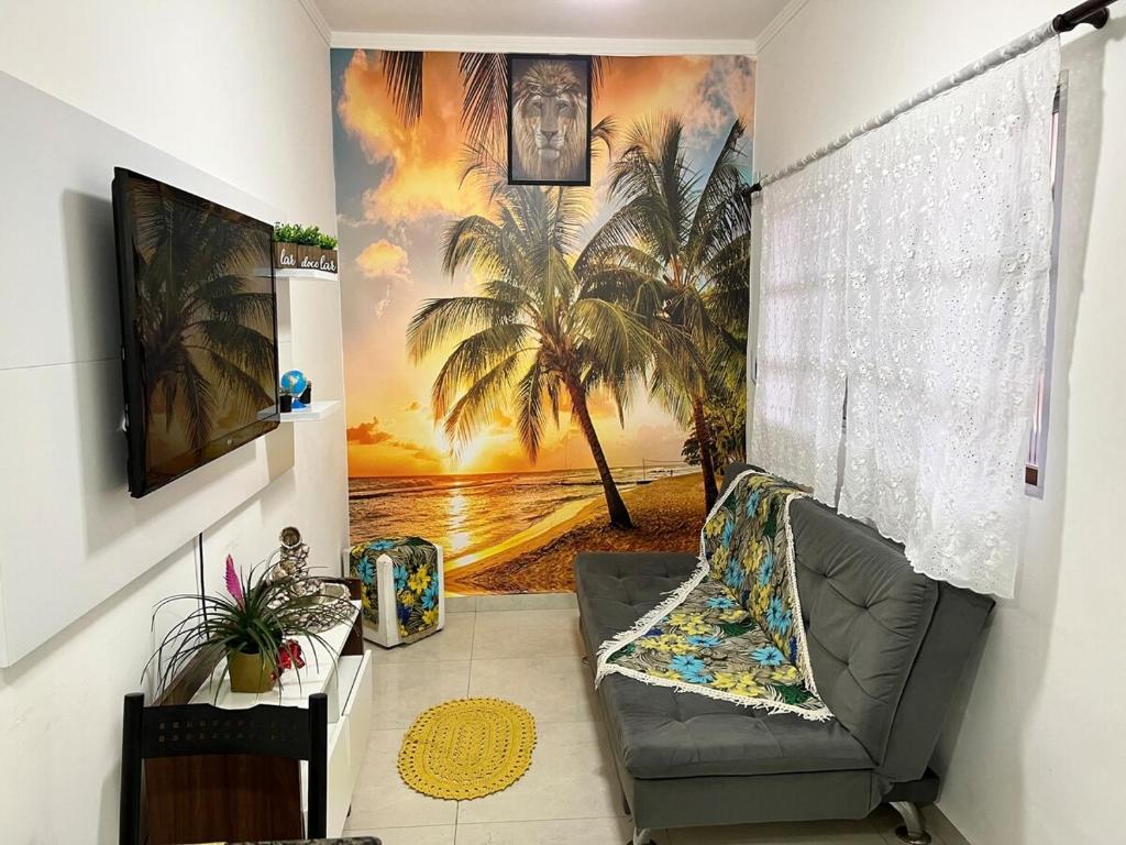 Una sala de estar con un mural de una playa y palmeras. en Apê na PG only 150 Metros da Praia, en Praia Grande