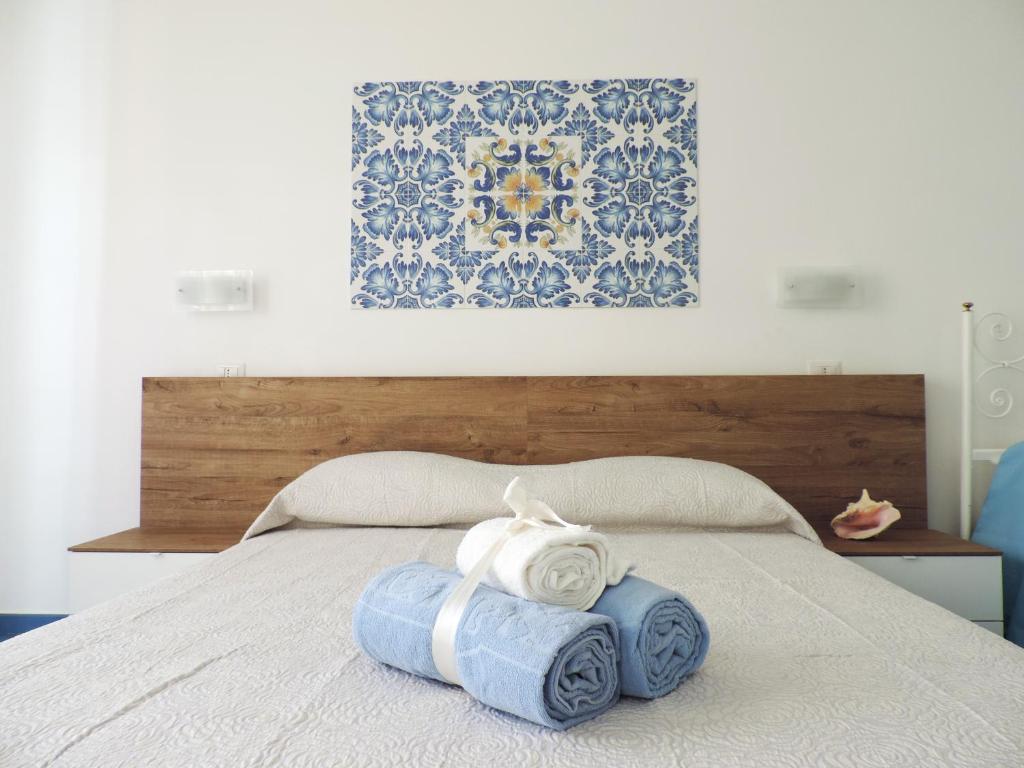 Una cama con dos toallas encima. en Mediterraneo Rooms, en Palinuro