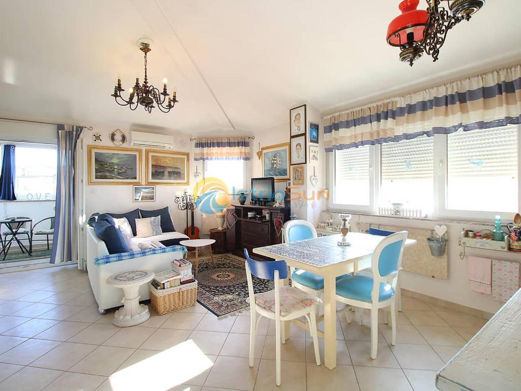 a living room with a table and blue chairs at Apartmani Ima in Ližnjan