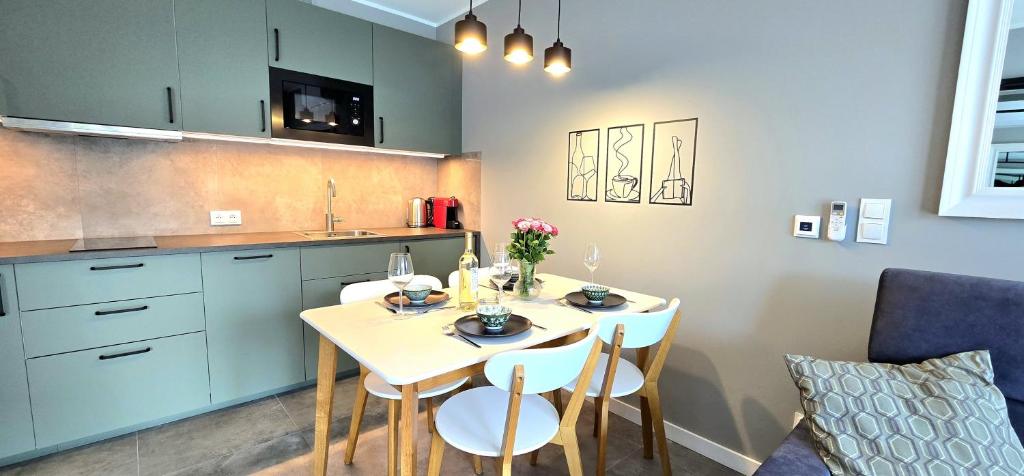 Una cocina con una mesa y sillas en una cocina. en Apartament Złota Plaża Jantar Resort by TriApart, en Jantar
