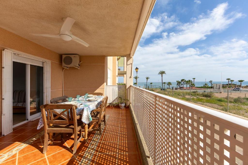 a balcony with a table and chairs and a view of the ocean at Apartamento Al Lado De La Playa in Pulpí
