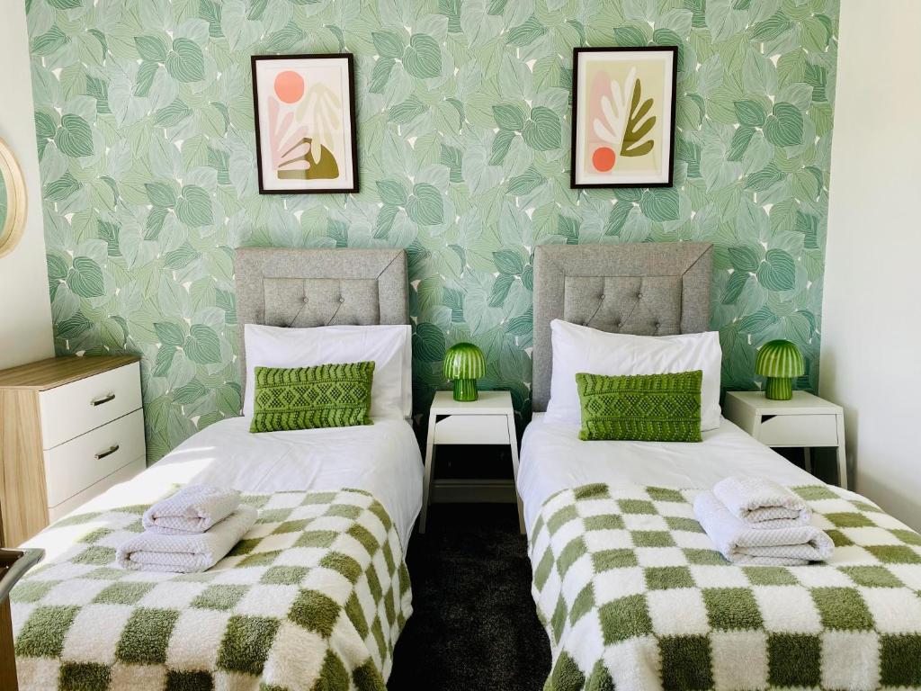 - 2 lits dans une chambre avec des draps verts et blancs dans l'établissement Blossomgate, à Halifax