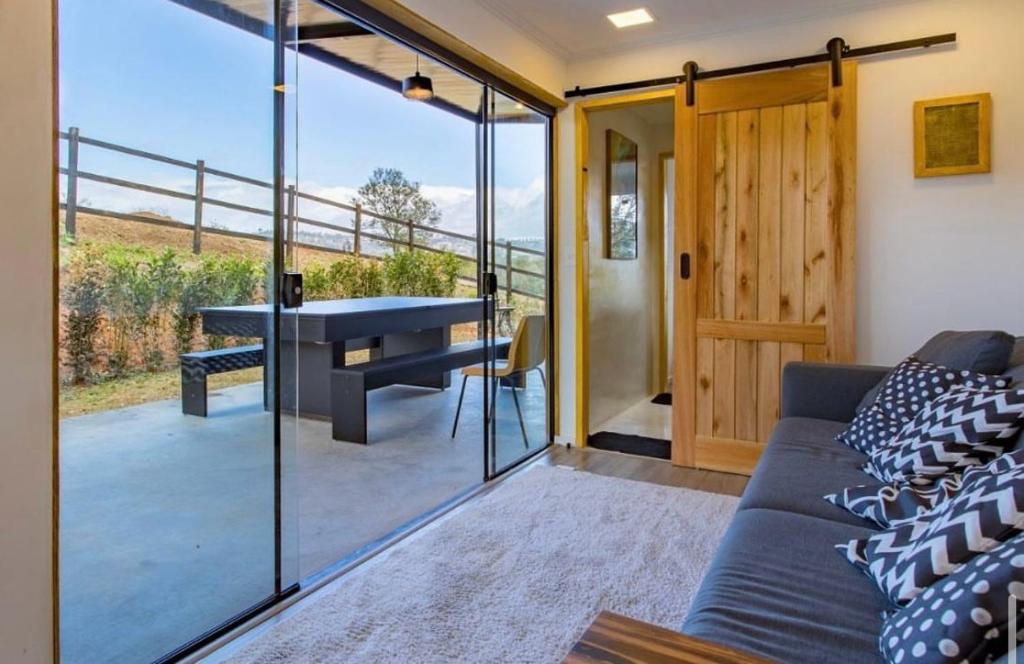 Una sala de estar con un sofá y una mesa en un balcón. en Arroyo & Grapes, en Campinas