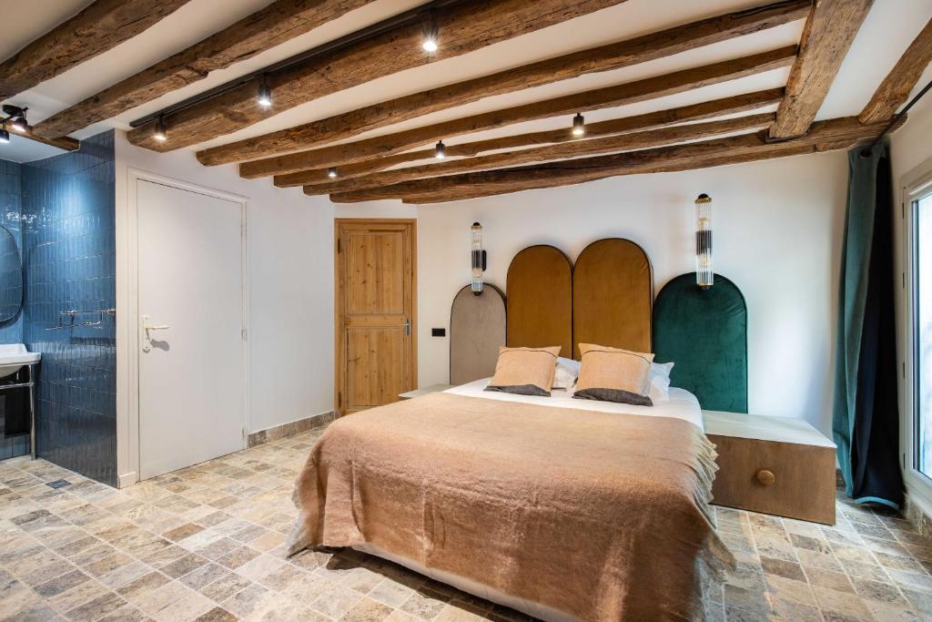 une chambre avec un grand lit et une salle de bain dans l'établissement CMG Amazing Duplex 3BR 6P Le Marais, à Paris